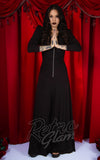 A woman wearing a black hooded jumpsuit. 