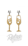 A pair of gold glitter champagne glass drop earrings with silver star-shaped studs
