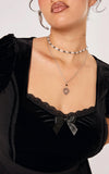 Victorian black velvet top with a lace sweetheart neckline and a black satin bow