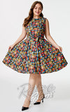 A woman modeling a sleeveless, high-neck, A-line swing dress with a colorful book print